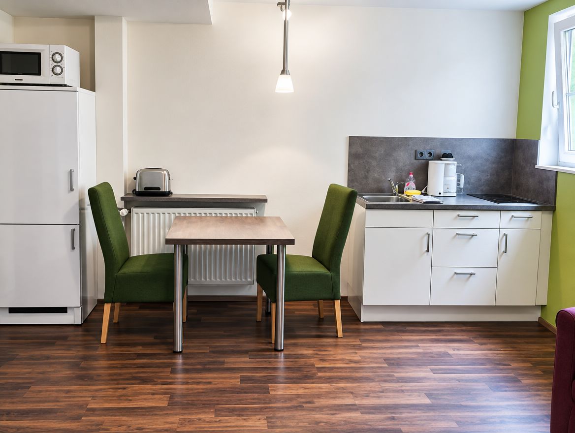 Küchenzeile mit Kühlschrank, Mikrowelle und Esstisch