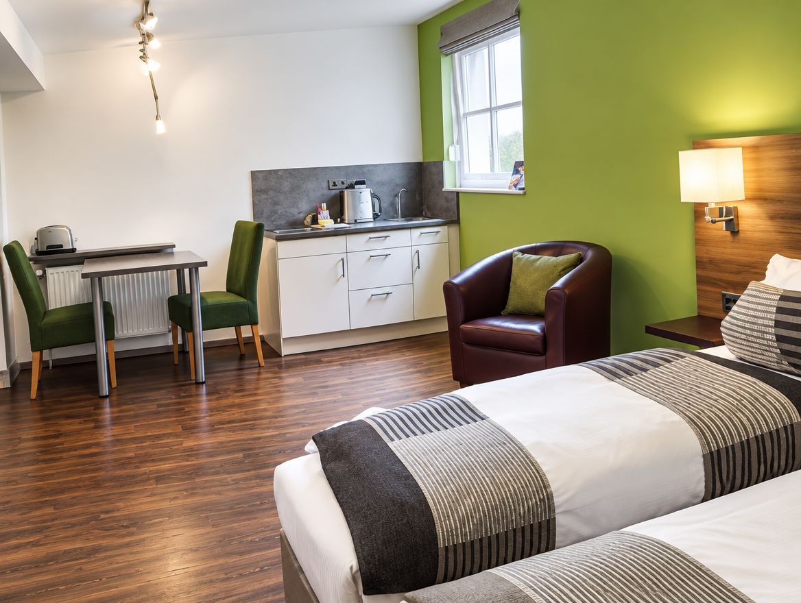 Apartment in Würzburg mit Betten, Sessel, Esstisch und Küchenzeile